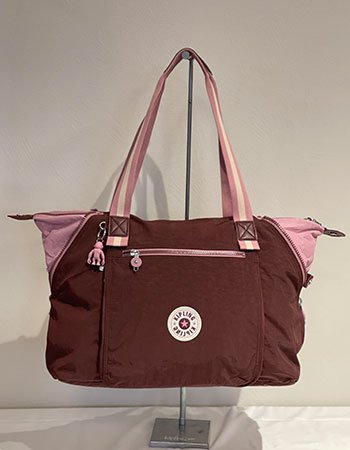 Modèle iconique de la marque KIPLING, Art M. Sac 48H multi-usages à porter à l’épaule. Ici coloris bordeaux et rose.