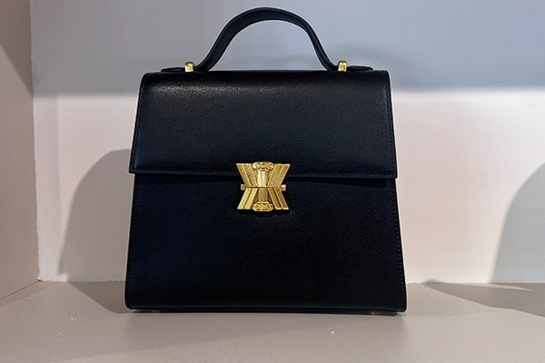 Sac Boxy en cuir de vachette noir porter main, bijouterie dorée, de la marque KASSANDRE, exposante sur le salon Who's Next janvier 2024